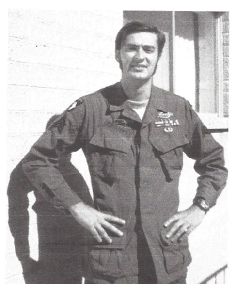 A black-and-white photograph of Sgt. Dean K. Phillips in uniform, hands on hips, standing on a porch.